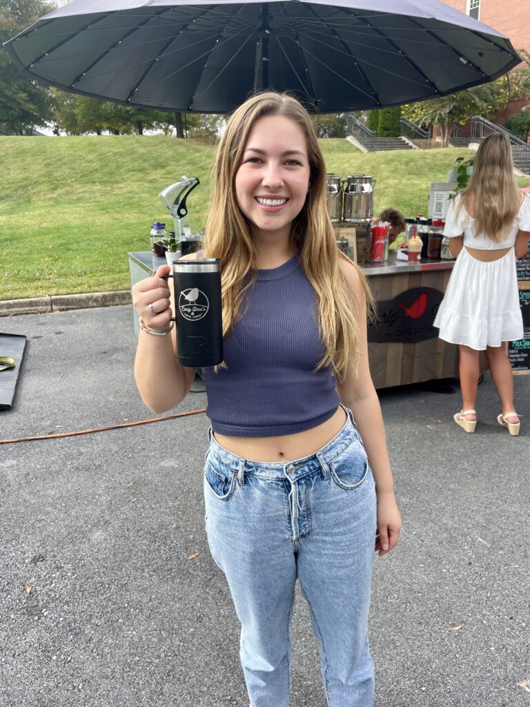 Nia Ailshie with her refillable Early Bird Coffee mug